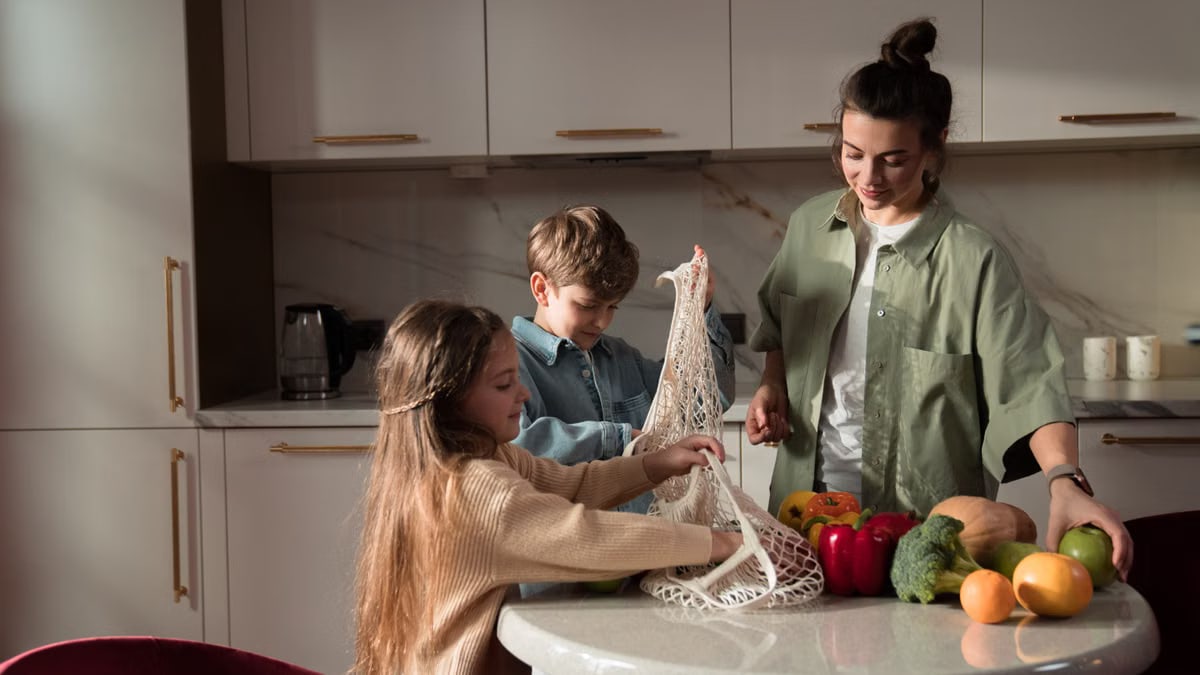 A happy family of three enjoying quality time unpacking vegetables in a modern kitchen.